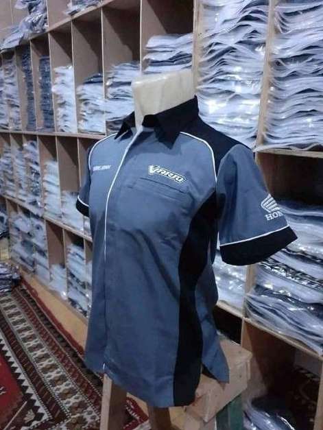 Two-tone branded work shirt on a mannequin in front of shelves of stock