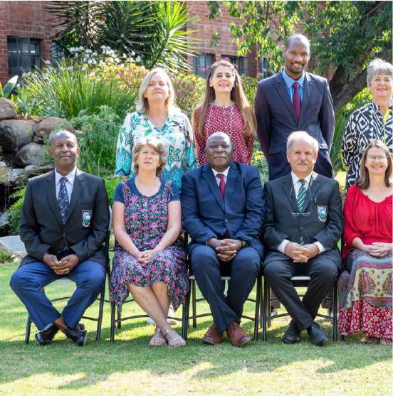 School staff seated and standing for a group portrait outdoors