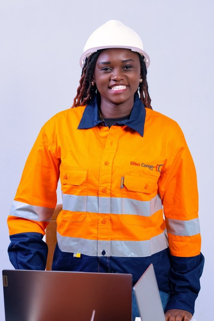 Smiling engineer in an orange hi-vis shirt and white hard hat