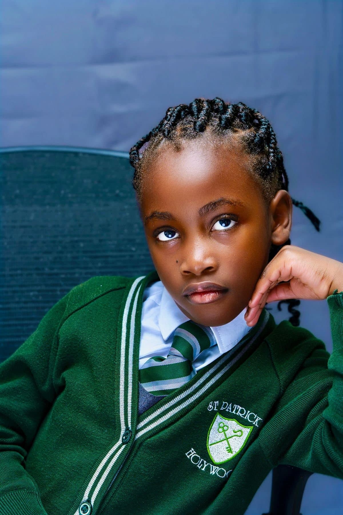 Child in a green school jersey with white stripes
